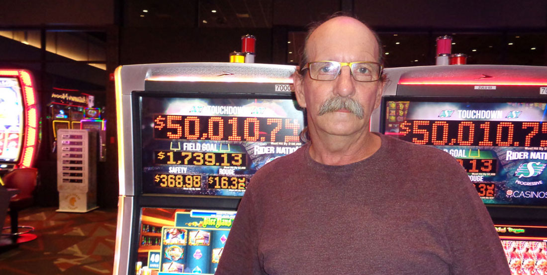 Man standing against slot machine after winning